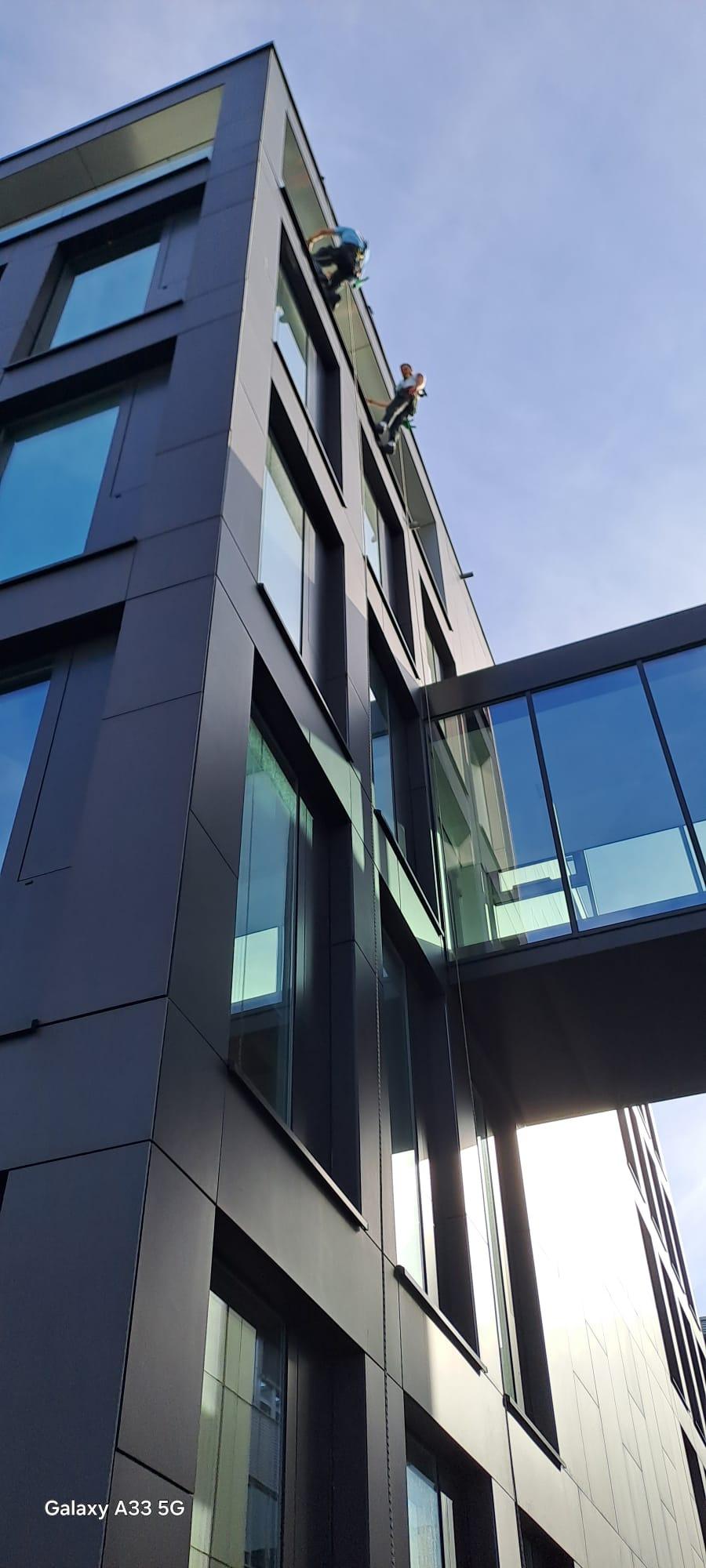 Seilzugang an einer hohen Glas- und Metallfassade