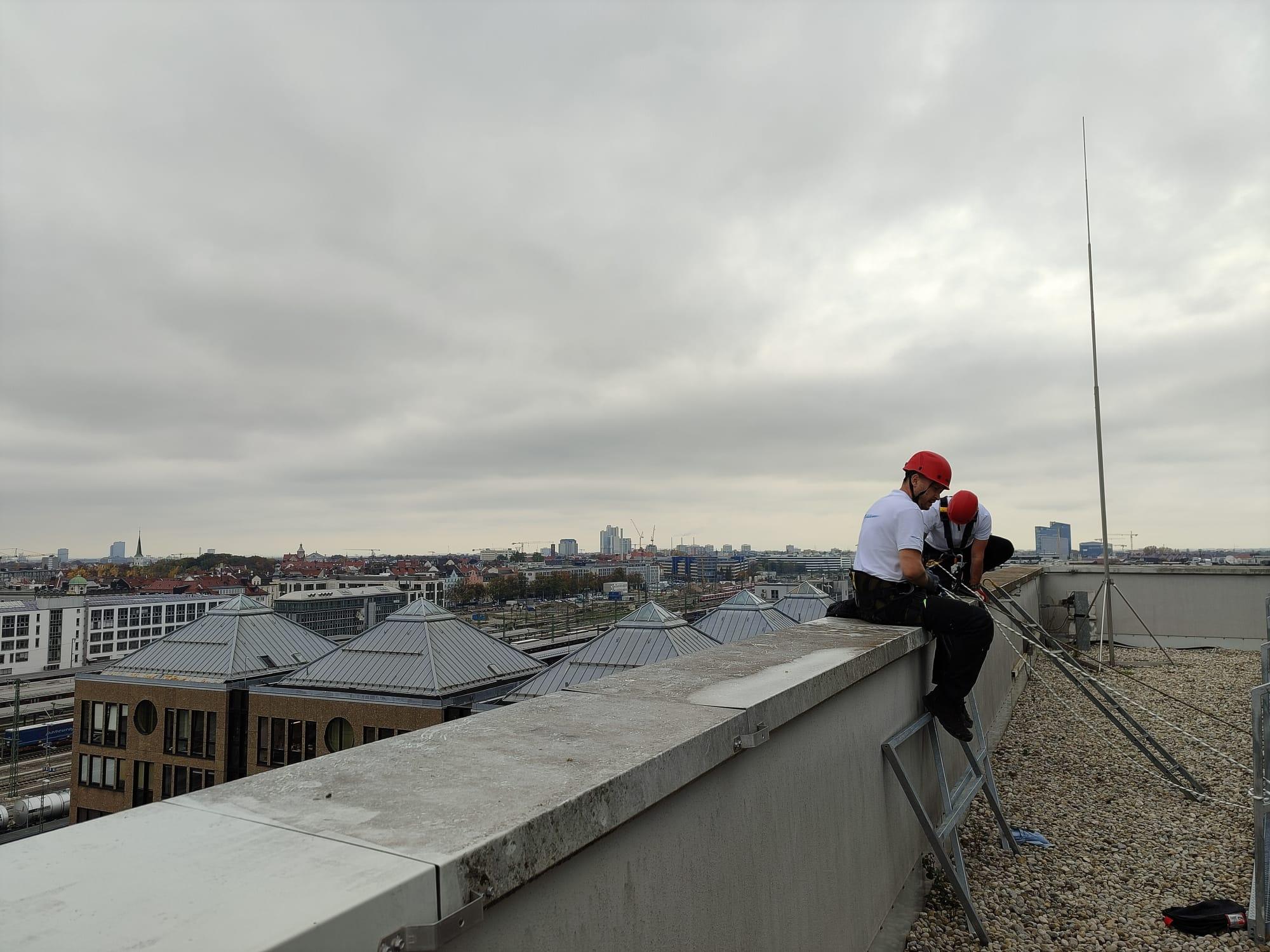 Vorbereitung am Seil an einer Dachkante mit Blick über die Stadt