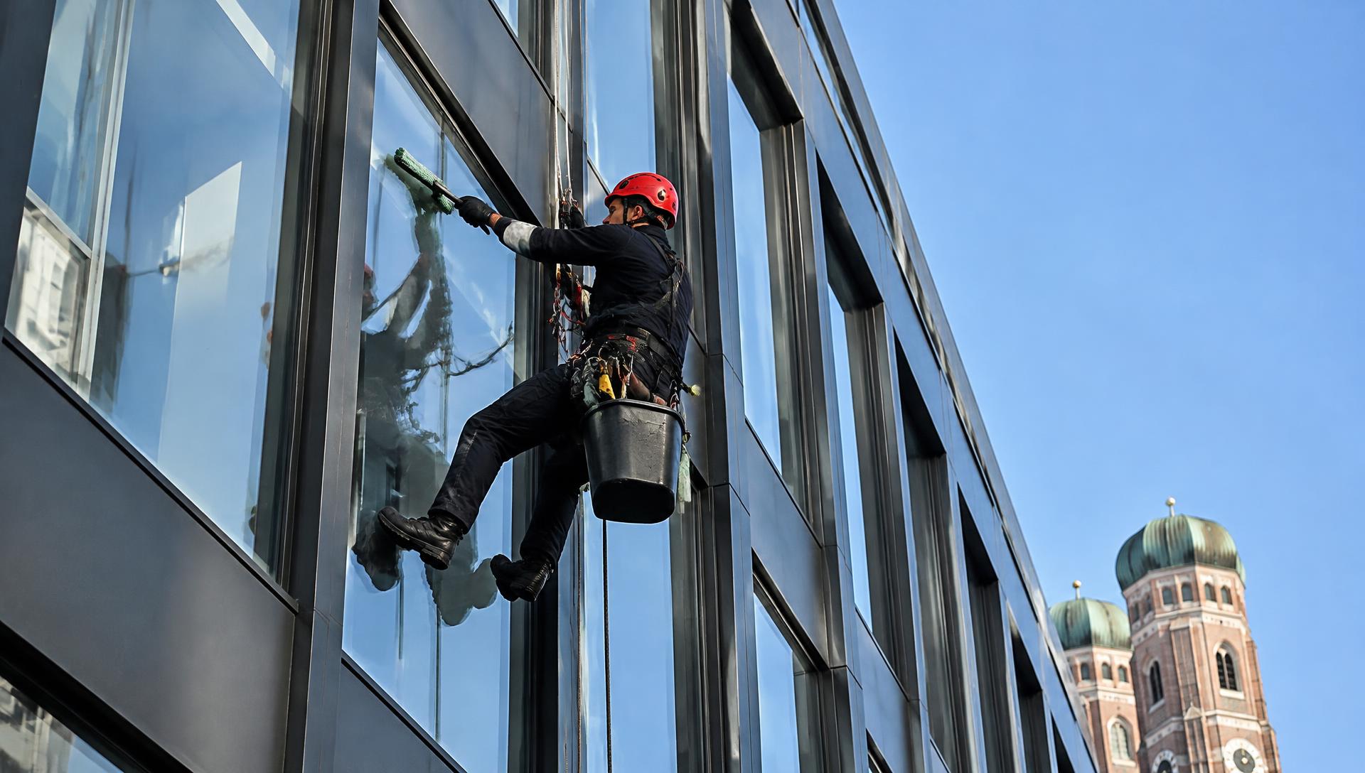 Industriekletterer reinigt eine Glasfassade in München